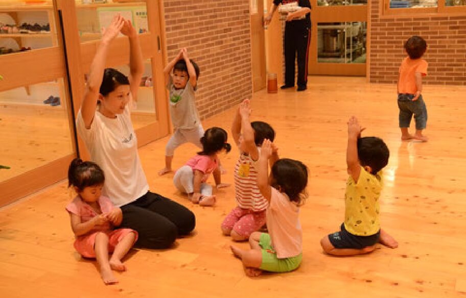 写真：先生と子どもたちが手のジェスチャーでコミュニケーションを取り合う様子