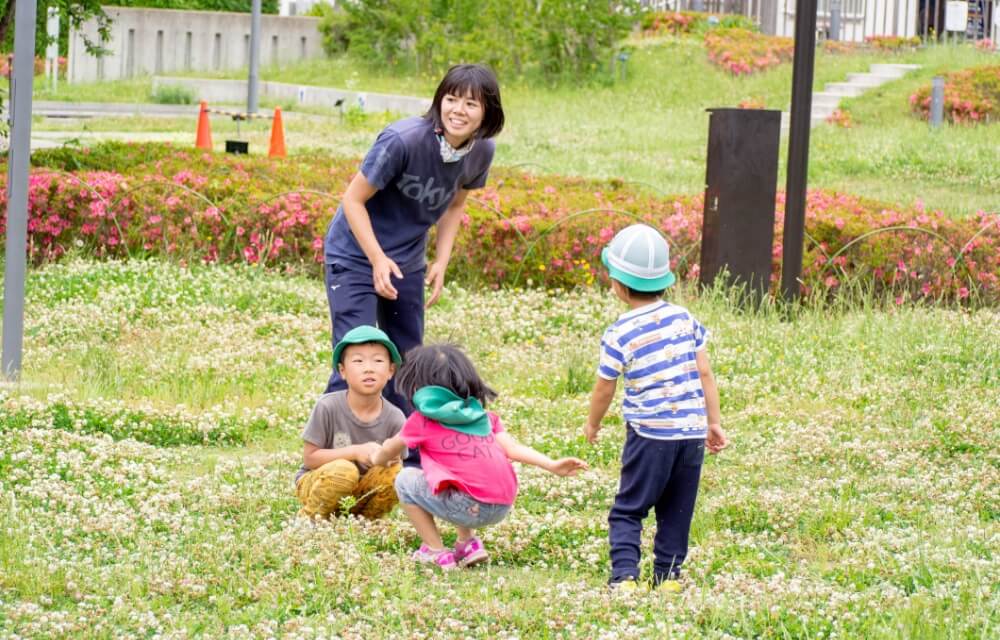 写真：草花に覆われた広場で子どもたちが遊ぶ様子