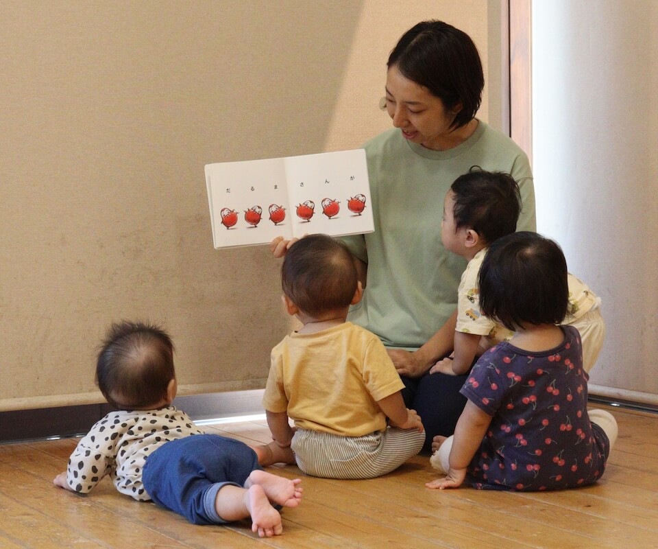 写真：保育園での過ごし方：絵本を読み聞かせる様子