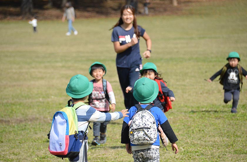 写真：笑顔で園児とコミュニケーションを取る保育士