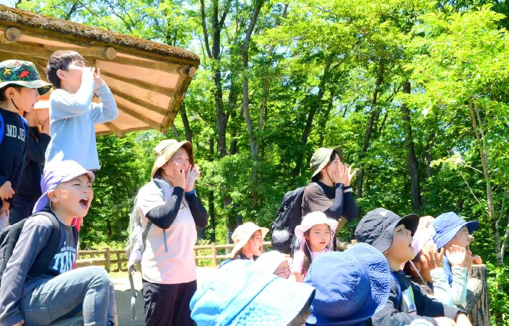 写真：自然豊かな屋外にて、みんなで叫んでいる様子