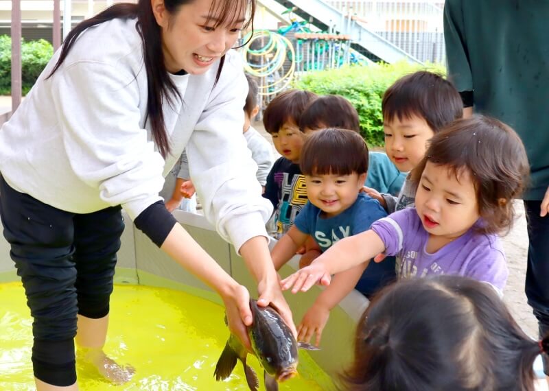 写真：魚を実際に手で触ってみる体験をする様子